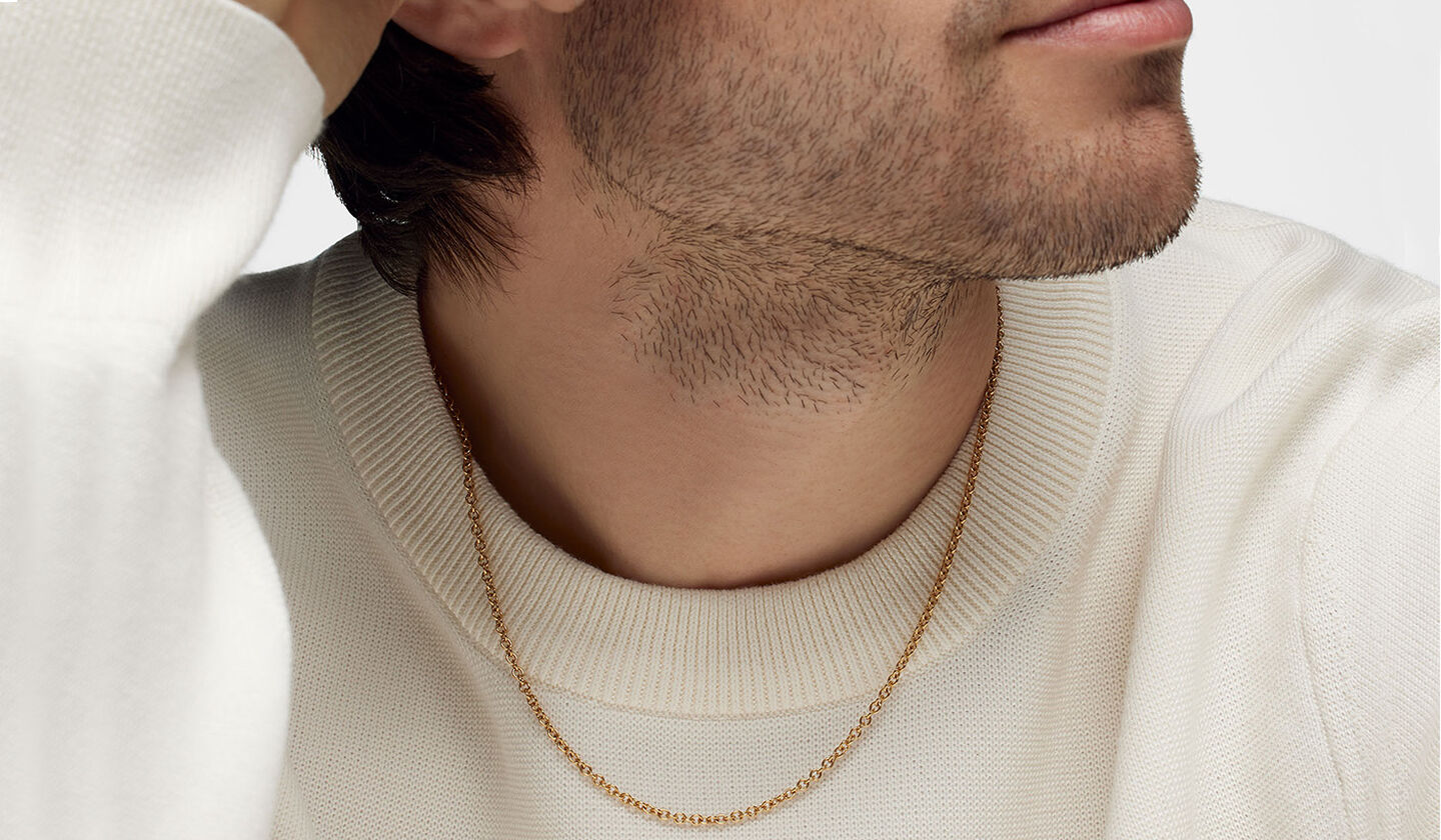 A man wearing a Birks Essentials yellow gold chain necklace.